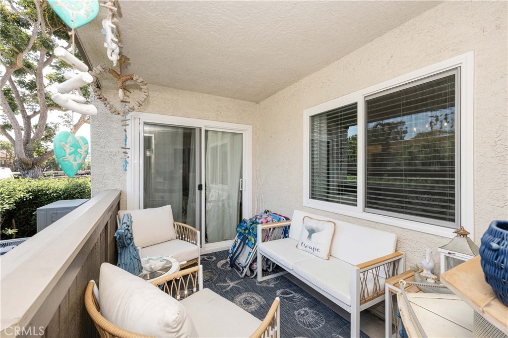 68 Corniche Drive, Unit B Dana Point, CA 92629 - Photo 31 of 35 a view of a patio with couches table and chairs with wooden floor and fence