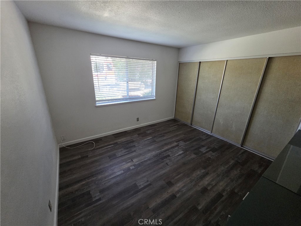 19145 Tomahawk Road Apple Valley, CA 92307 - Photo 12 of 38 a view of an empty room with wooden floor and a window
