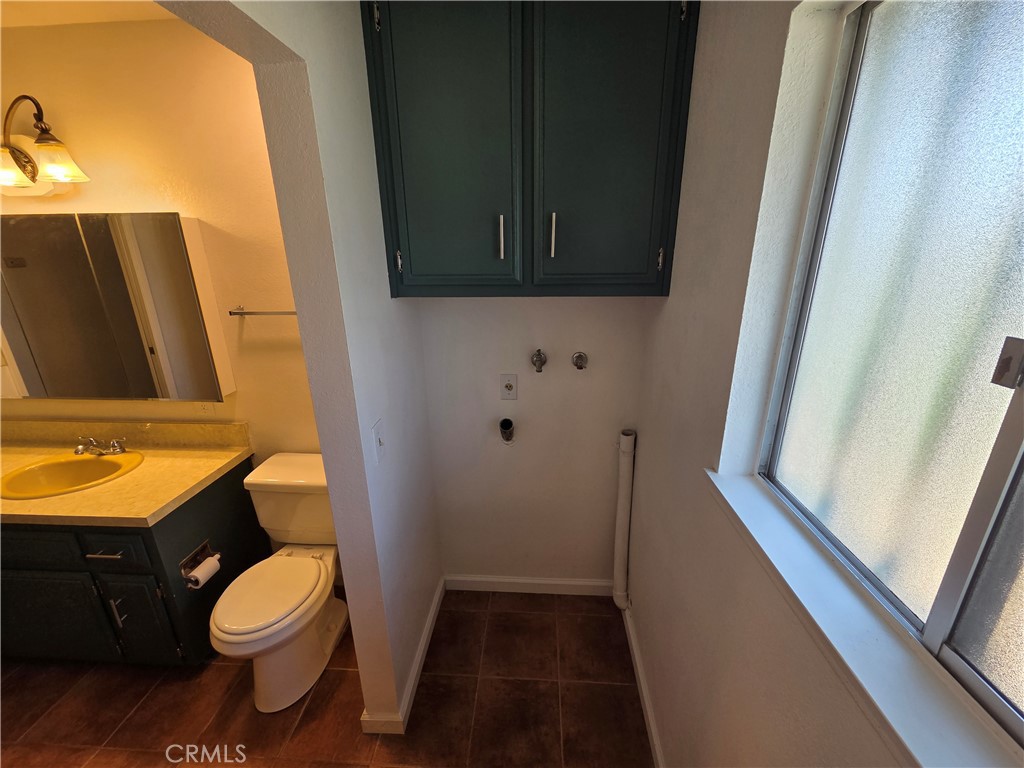 19145 Tomahawk Road Apple Valley, CA 92307 - Photo 15 of 38 a bathroom with a toilet a sink and a mirror