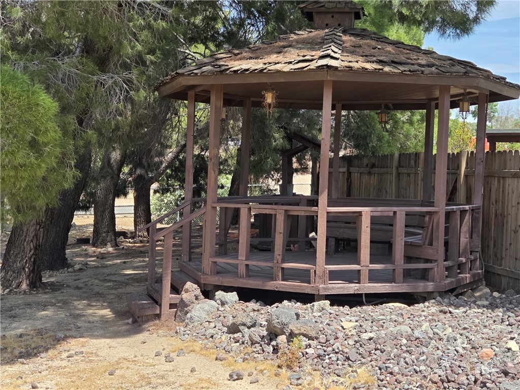 19145 Tomahawk Road Apple Valley, CA 92307 - Photo 32 of 38 a view of a blue house with a large window and lawn chair under an umbrella