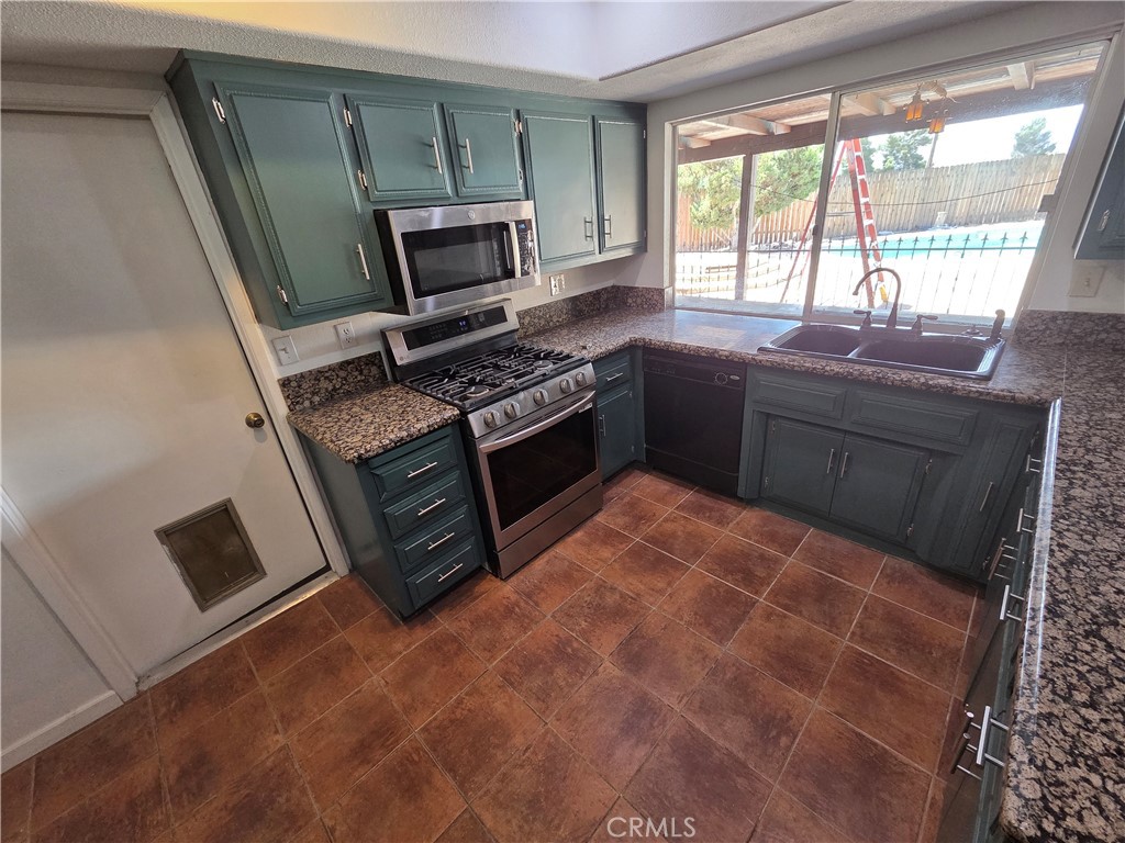 19145 Tomahawk Road Apple Valley, CA 92307 - Photo 8 of 38 a kitchen with a stove a sink and a microwave