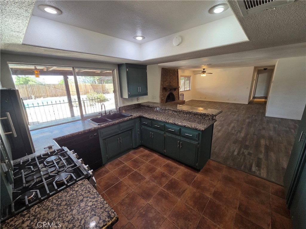 19145 Tomahawk Road Apple Valley, CA 92307 - Photo 9 of 38 a kitchen with stainless steel appliances granite countertop a stove a sink and a microwave