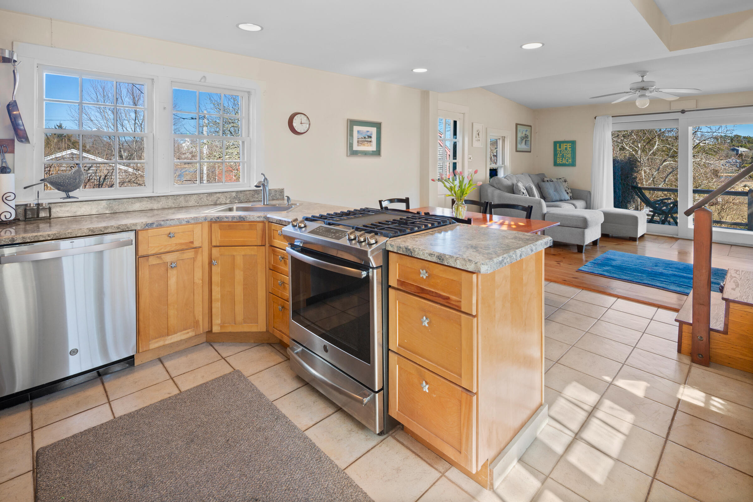 115 Commercial Street, Unit B Wellfleet, MA 02667 - Photo 13 of 37 a kitchen with stainless steel appliances granite countertop a stove a sink and a microwave