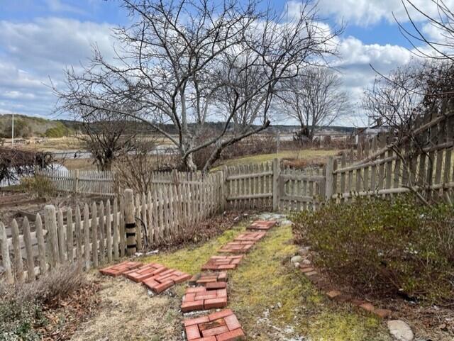 115 Commercial Street, Unit B Wellfleet, MA 02667 - Photo 29 of 37 a view of a pathway of a house with large trees and wooden fence