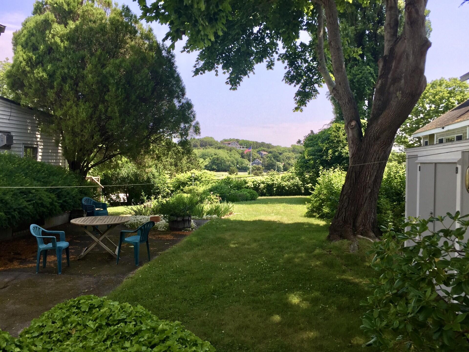 115 Commercial Street, Unit B Wellfleet, MA 02667 - Photo 33 of 37 a view of a house with backyard sitting area and garden