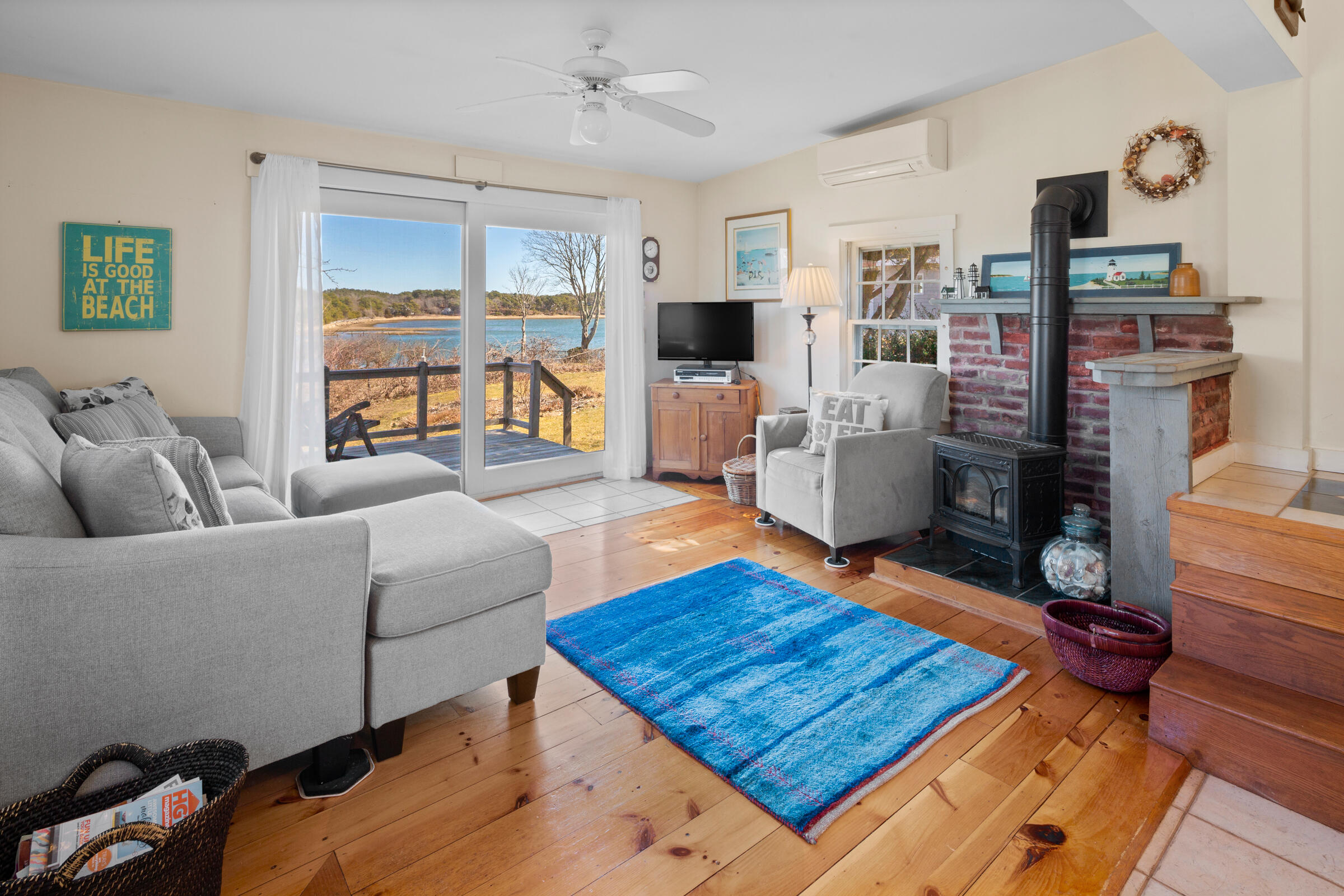 115 Commercial Street, Unit B Wellfleet, MA 02667 - Photo 6 of 37 a living room with furniture flat screen tv and a fireplace