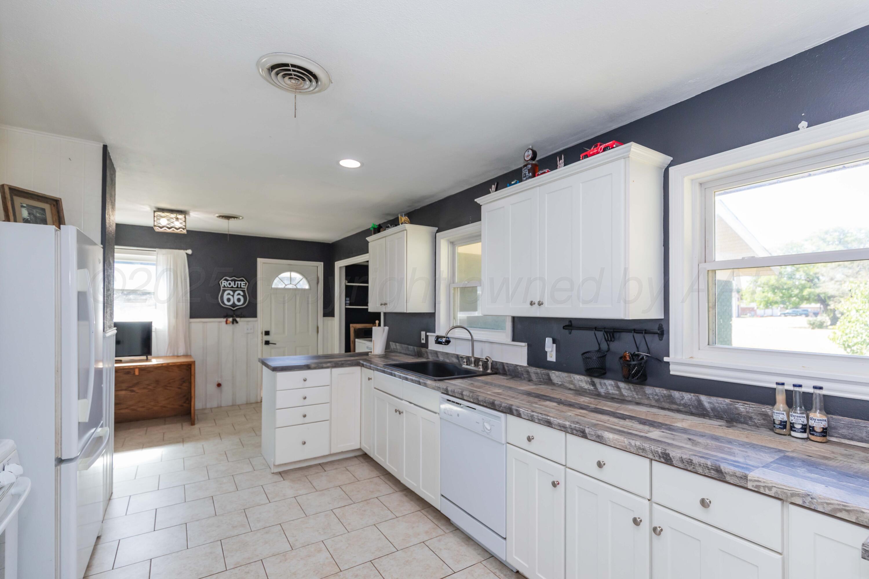 315 Pratt Street Claude, TX 79019 - Photo 17 of 38 a large white kitchen with granite countertop a sink window and cabinets