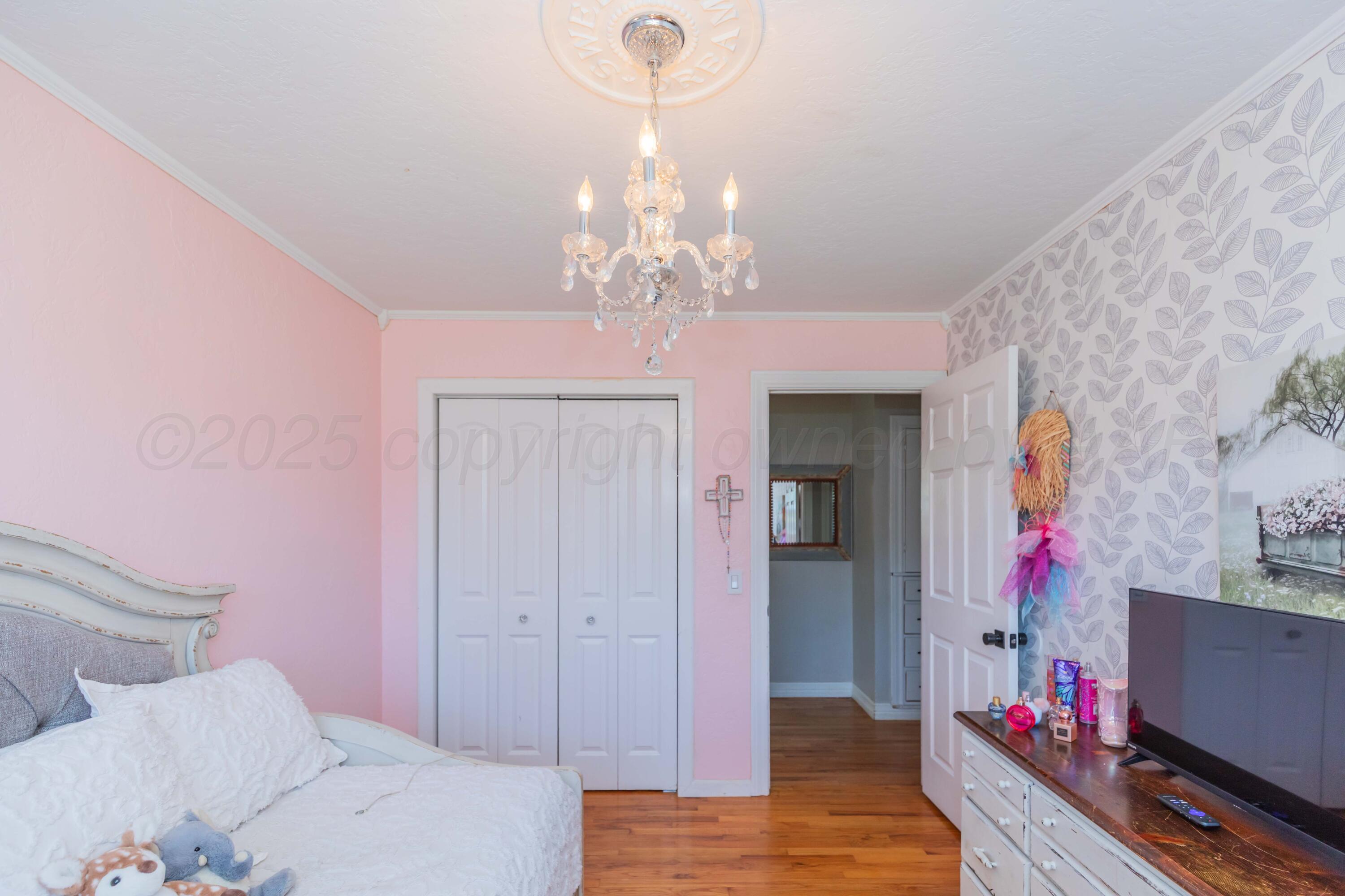 315 Pratt Street Claude, TX 79019 - Photo 21 of 38 a bedroom with bed and a chandelier