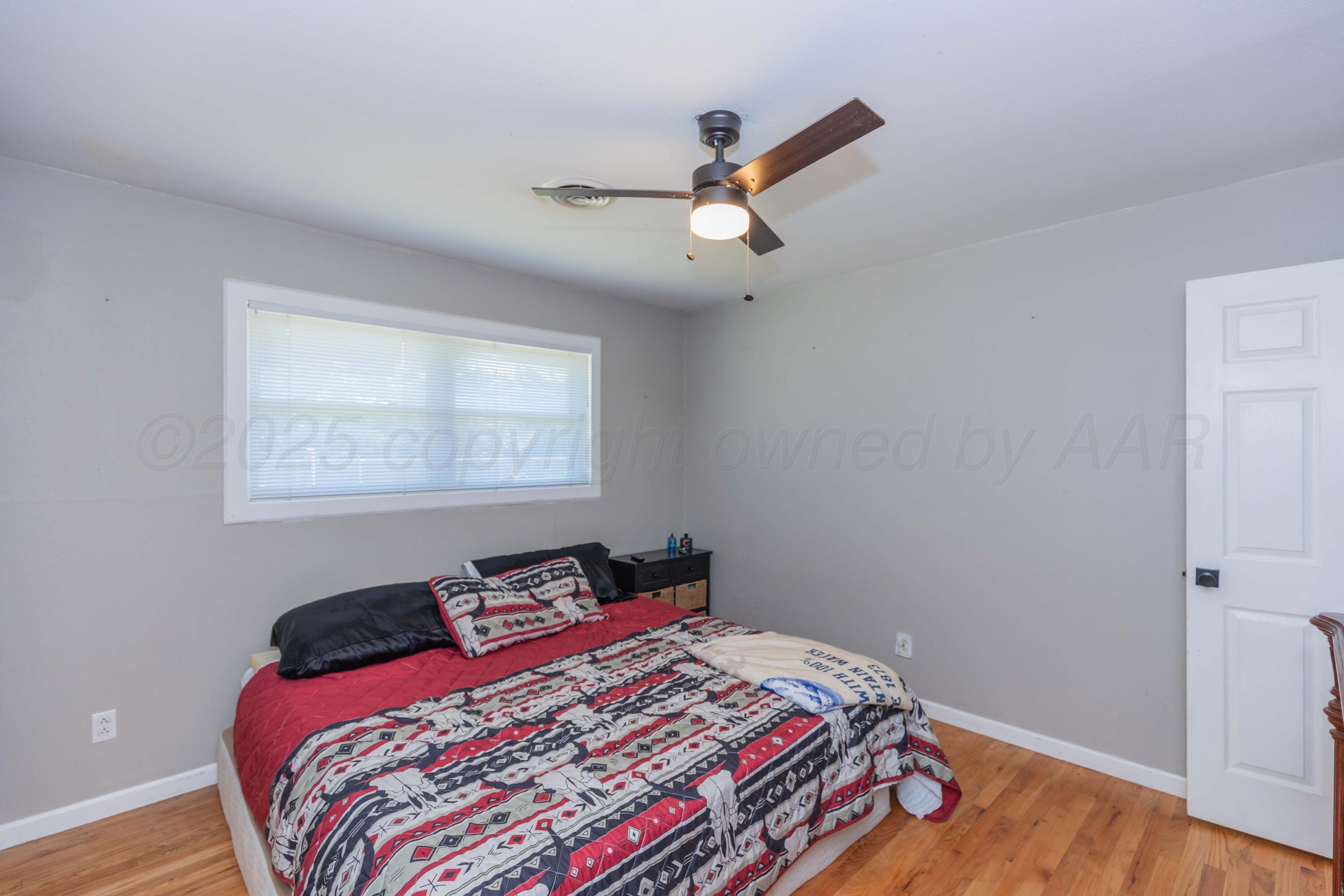 315 Pratt Street Claude, TX 79019 - Photo 27 of 38 a bedroom with a bed and wooden floor