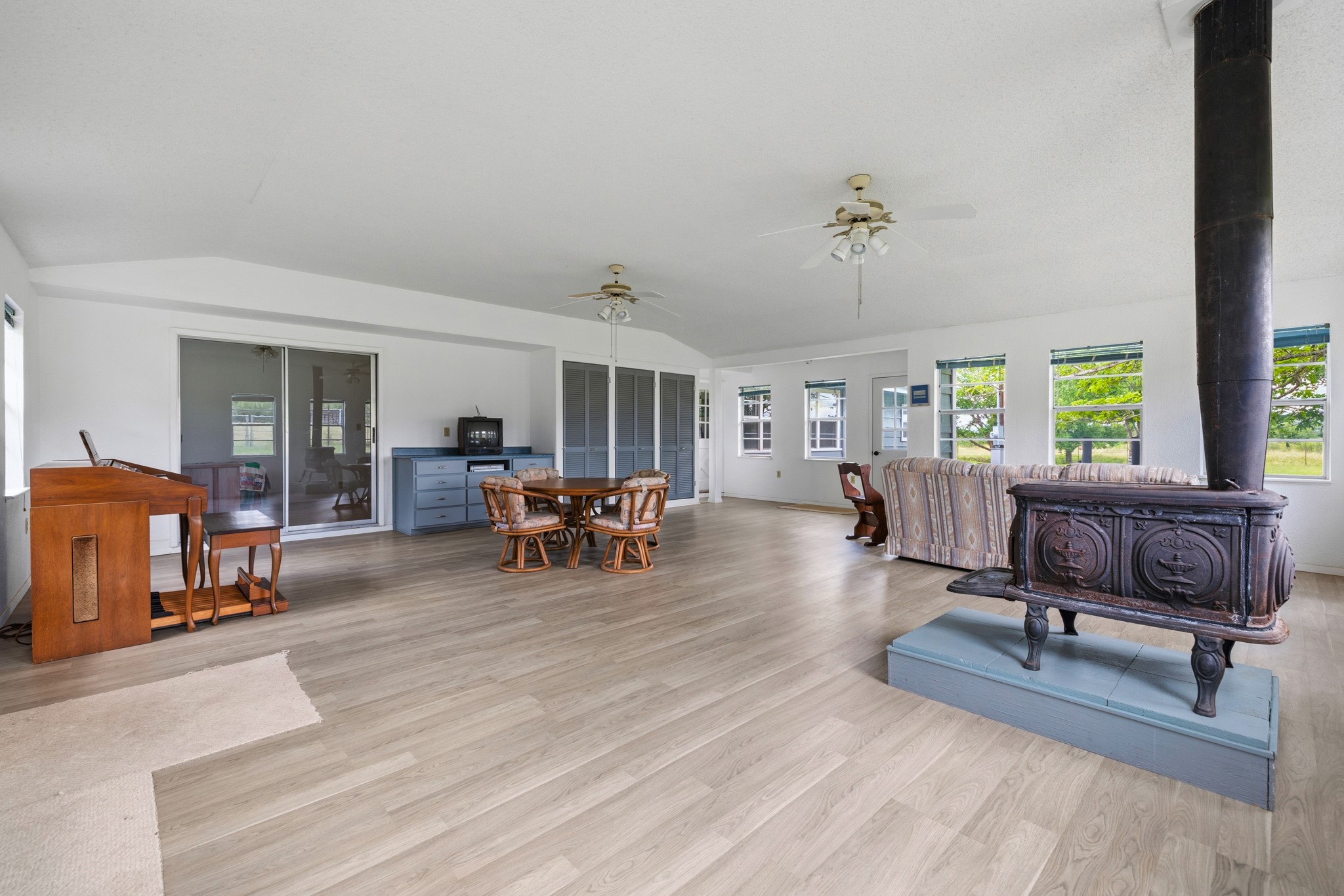 341 River View Road Fredericksburg, TX 78624 - Photo 17 of 40 An open layout highlights light-toned wood flooring and a vintage wood-burning stove.