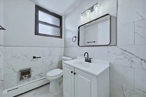a bathroom with a toilet sink and mirror