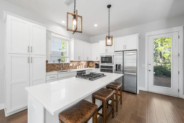 a kitchen with kitchen island a table and chairs