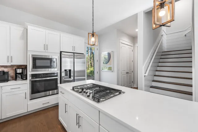 a kitchen with white cabinets and appliances