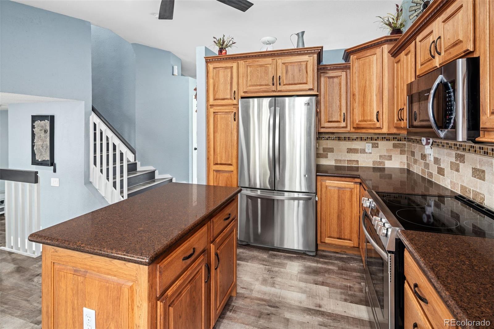 9677 South Castle Ridge Circle Highlands Ranch, CO 80129 - Photo 12 of 24 a kitchen with granite countertop a refrigerator a stove and a sink