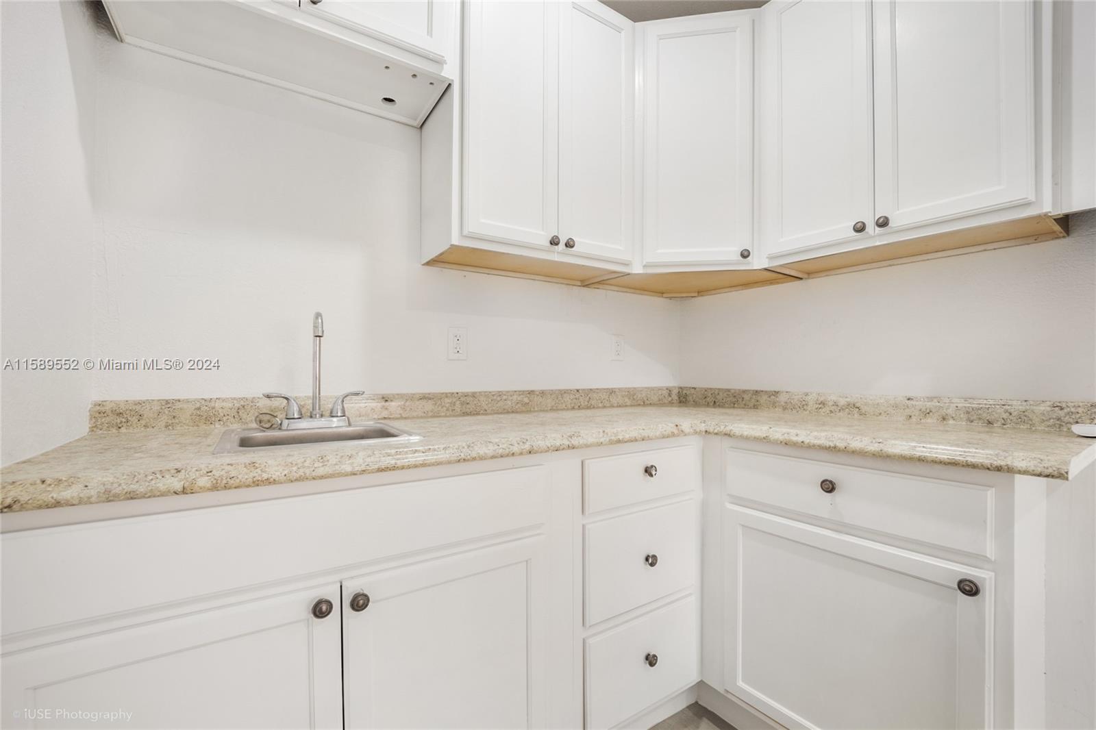2130 Northwest 28th Street Miami, FL 33142 - Photo 19 of 48 a kitchen with granite countertop white cabinets and a sink