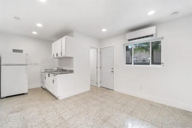 a kitchen with stainless steel appliances granite countertop a sink and a white refrigerator