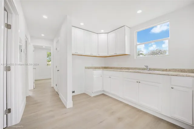 a view of a kitchen with white cabinets