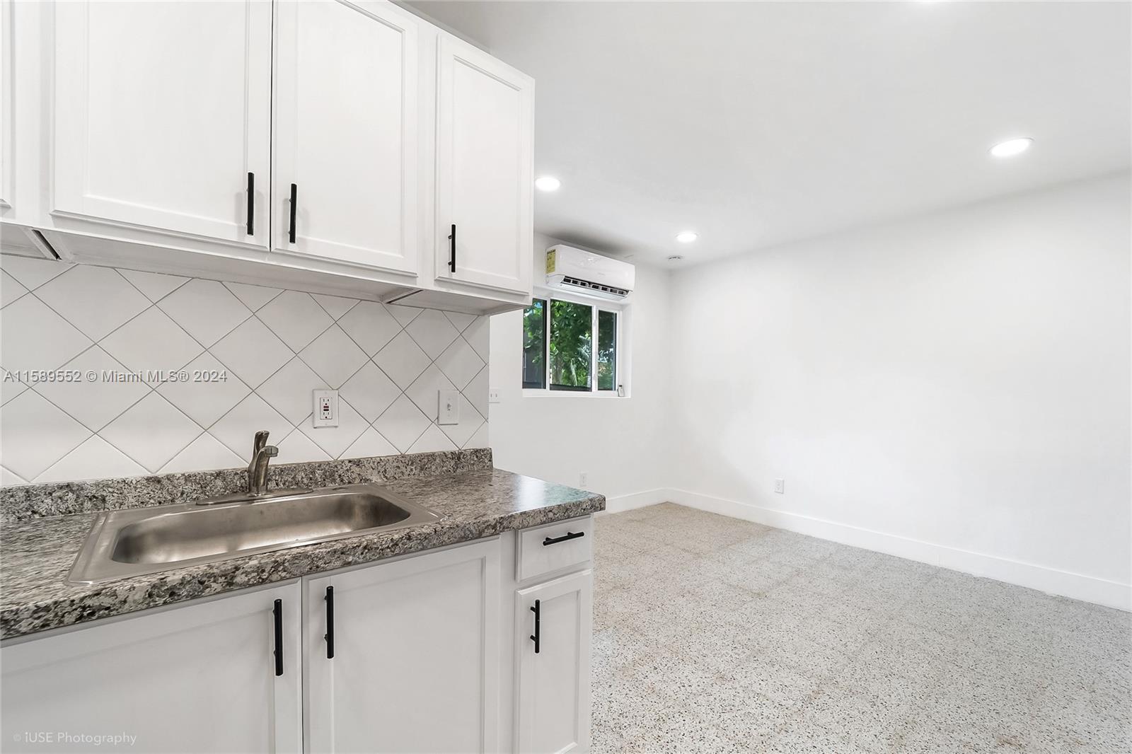 2130 Northwest 28th Street Miami, FL 33142 - Photo 32 of 48 a kitchen with granite countertop white cabinets and a sink