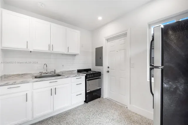 a kitchen with granite countertop a stove sink and cabinets