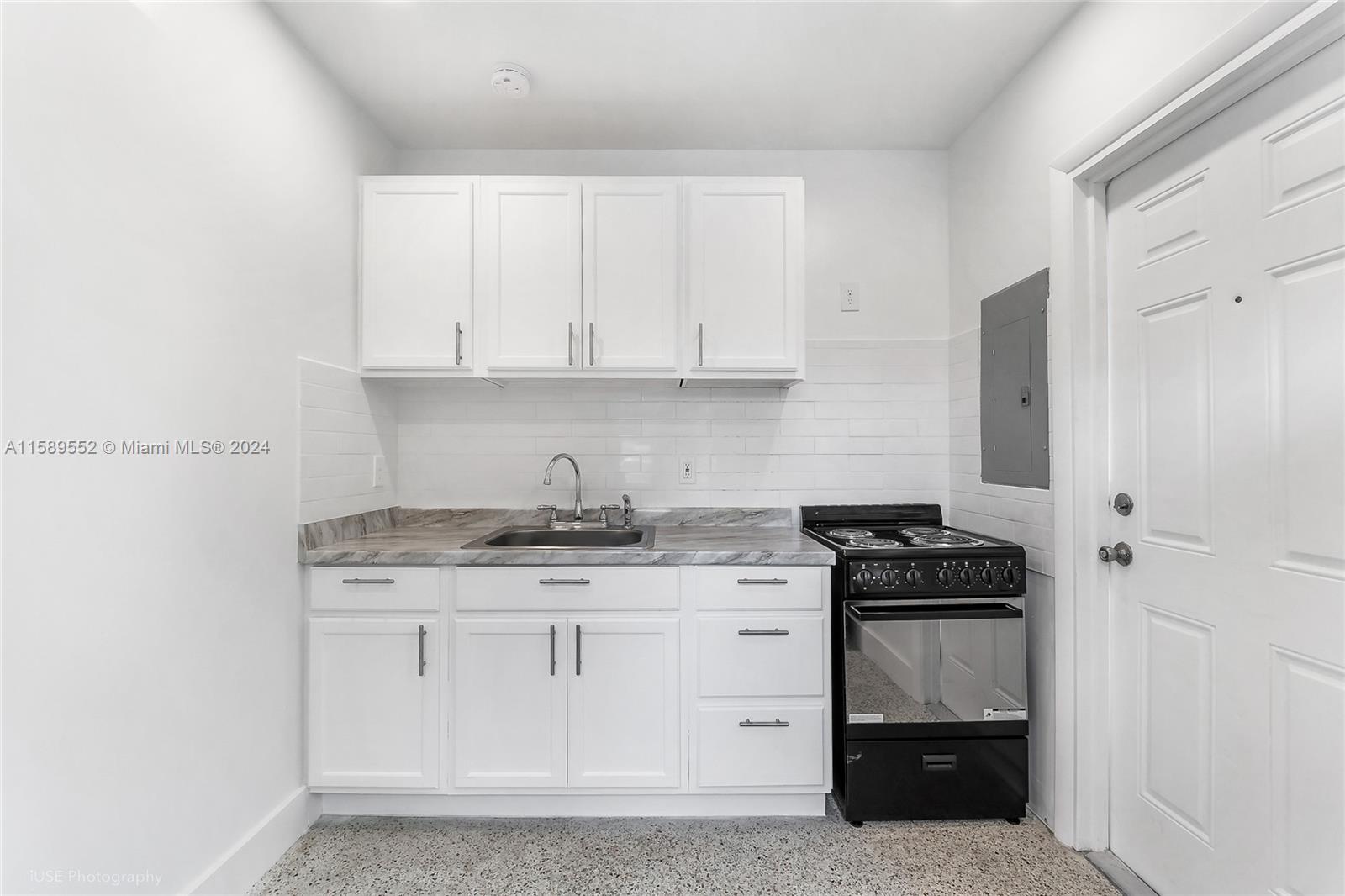 2130 Northwest 28th Street Miami, FL 33142 - Photo 48 of 48 a kitchen with granite countertop a stove sink and cabinets