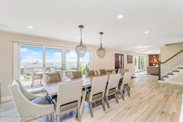 a kitchen with white cabinets stainless steel appliances and dining table