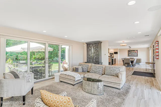 a view of a dining room and livingroom with furniture wooden floor a chandelier