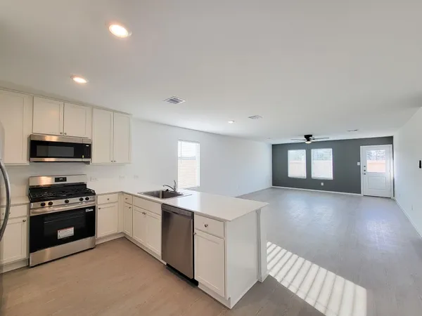 a kitchen with granite countertop a stove top oven and cabinets