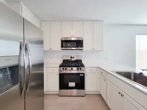 a kitchen with stainless steel appliances granite countertop a stove a refrigerator and a sink