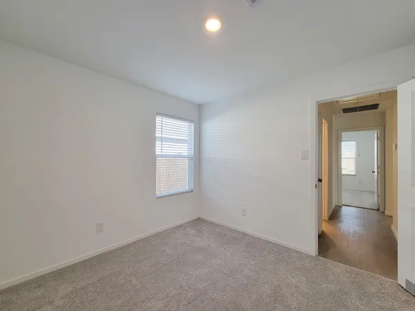 an empty room with windows and closet