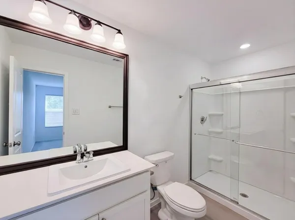 a bathroom with a sink a toilet and mirror