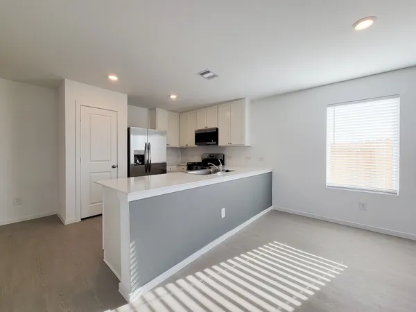 a kitchen with stainless steel appliances granite countertop a refrigerator sink and white cabinets