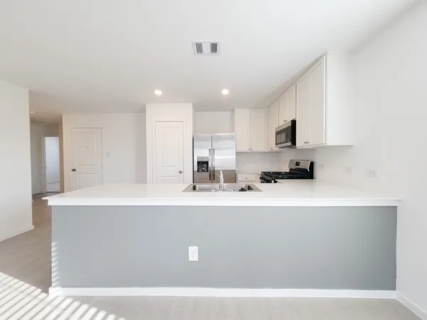 a kitchen with kitchen island sink and stove