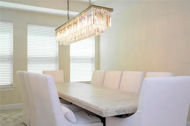 a view of a dining room with furniture large windows and a chandelier