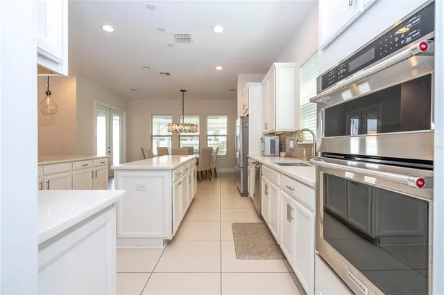 a dining room with furniture and a floor to ceiling window