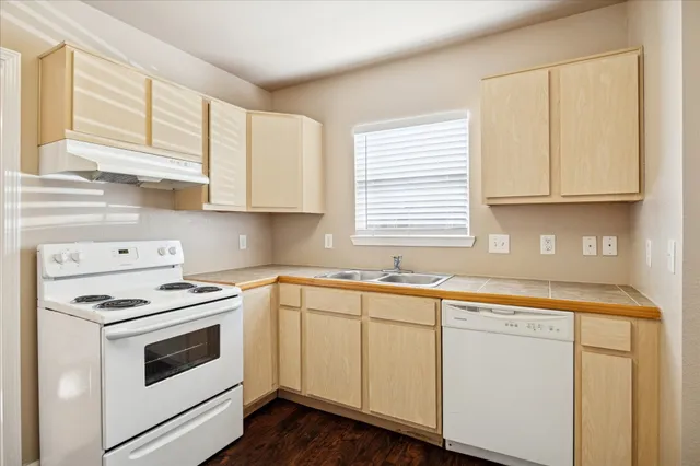 a kitchen with granite countertop white cabinets and white appliances