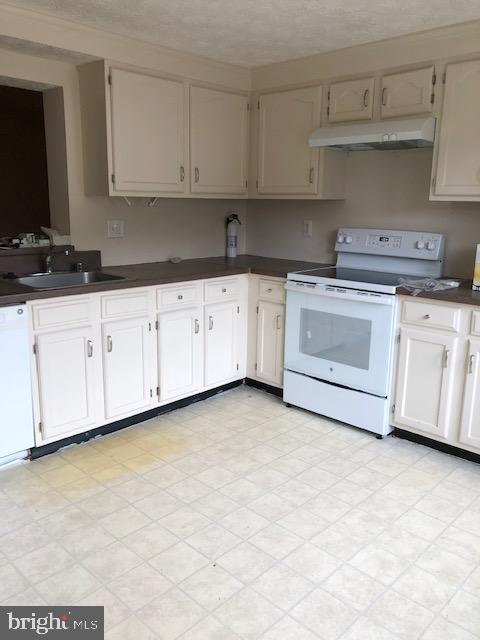 7516 Mandan Road Greenbelt, MD 20770 - Photo 13 of 15 a kitchen with granite countertop white cabinets and stainless steel appliances