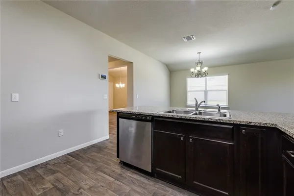 a kitchen with granite countertop a sink and cabinets