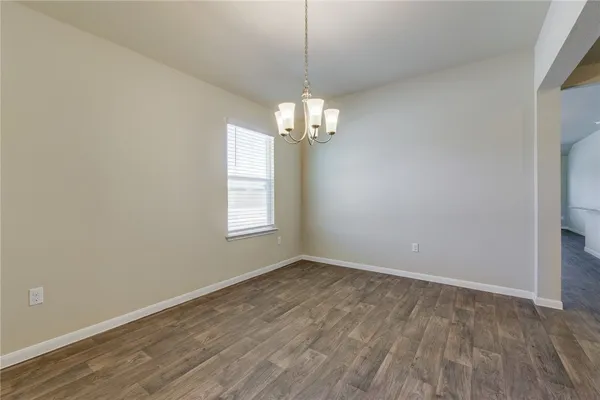 a view of a room with wooden floor chandelier and window