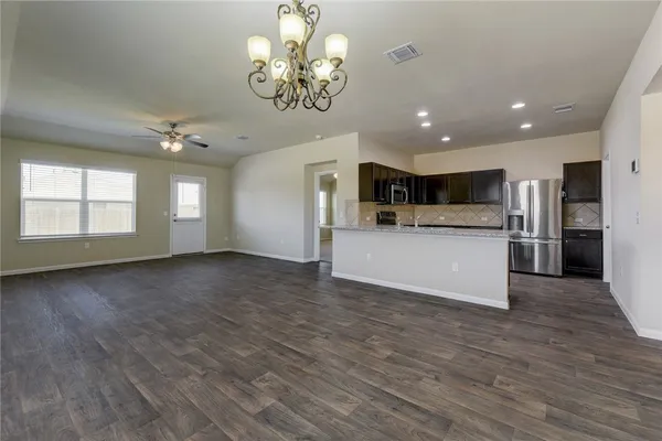 a view of a big room with wooden floor and a kitchen