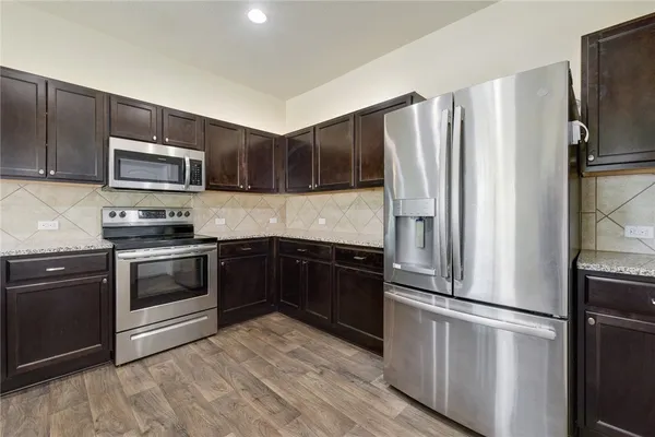 a kitchen with stainless steel appliances and wooden cabinets