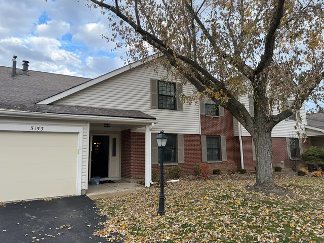a view of a house with a tree in front