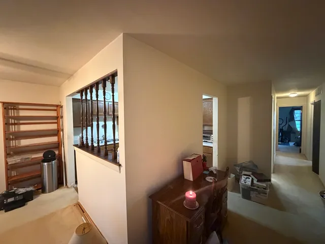 a hallway with a white stove top oven and couches with wooden floor