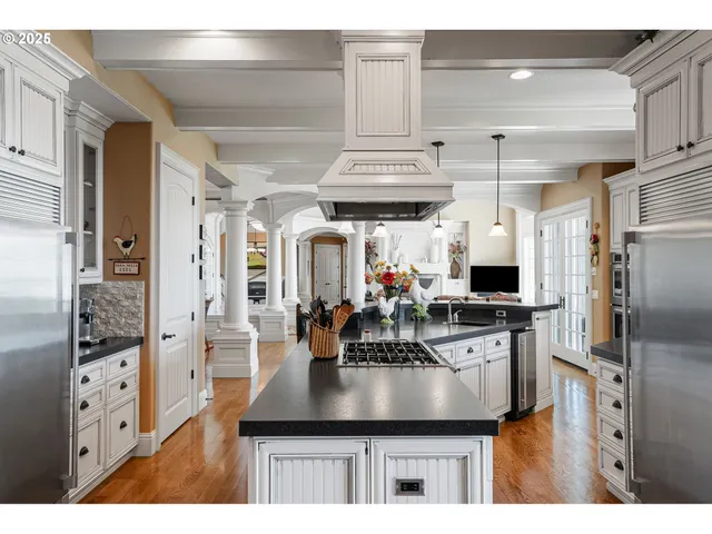 a kitchen with stainless steel appliances kitchen island granite countertop a sink refrigerator and cabinets