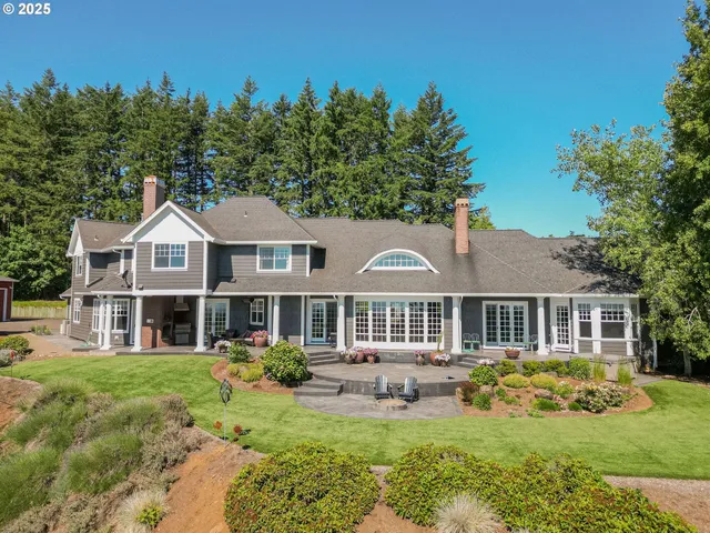 a view of a house with backyard and sitting area