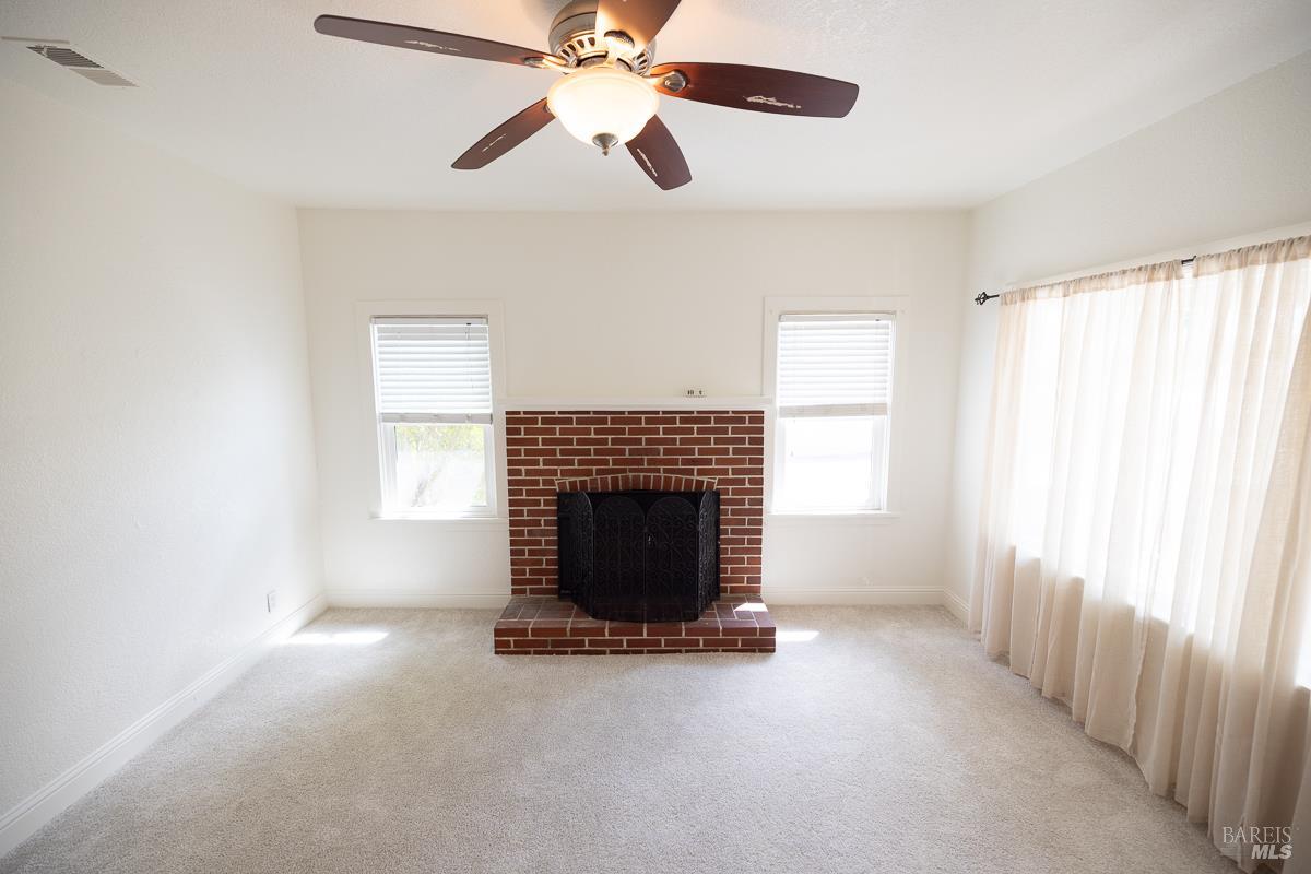 1685 West College Avenue Santa Rosa, CA 95401 - Photo 18 of 45 an empty room with windows fireplace and fan