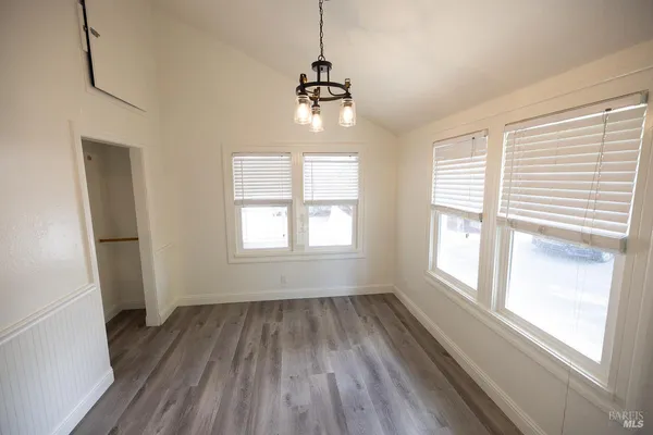 a room with wooden floor and windows