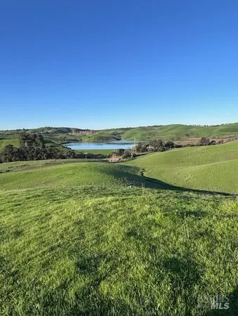 a view of a green field with an ocean view