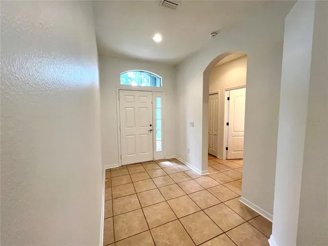 a view of a livingroom with wooden floor and a refrigerator