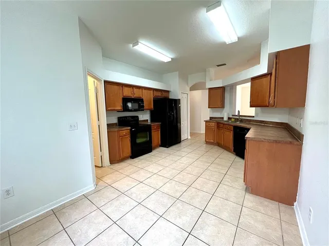 a view of a big room with windows and chandelier fan