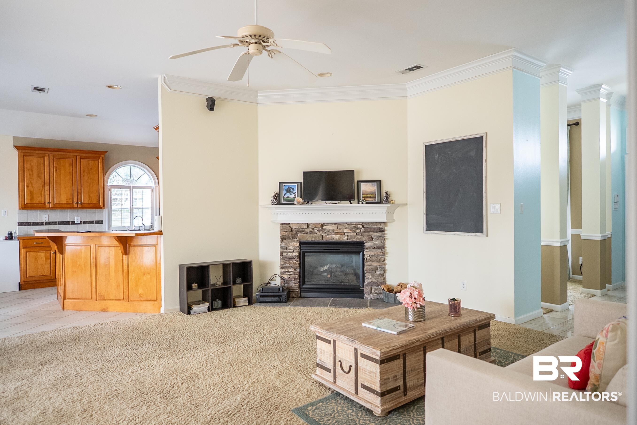 10023 Springfield Court Mobile, AL 36695 - Photo 11 of 50 Living room with a fireplace, ceiling fan, light tile patterned flooring, crown molding, and light colored carpet